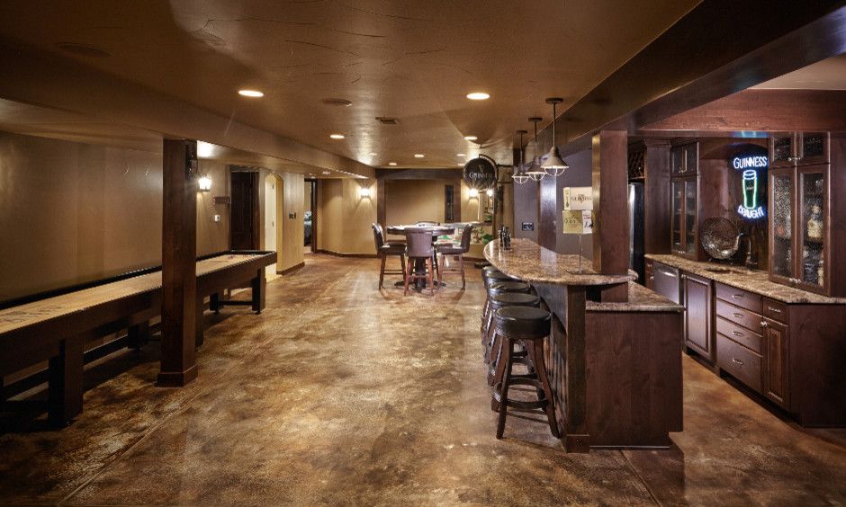 Acid Stained Concrete for a Traditional Basement with a Game Room and Shallow Pond by Highcraft Builders