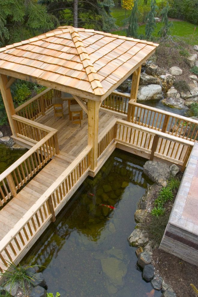 Aquascape for a Rustic Landscape with a Wooden Structure and Outdoor Living with Water Gardens by Aquascape Inc.
