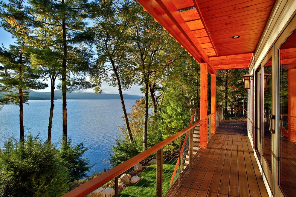 Conestoga Log Cabins for a Rustic Deck with a Engineered Wood Flooring and Bolton Landing Modern Cabin by Teakwood Builders, Inc.