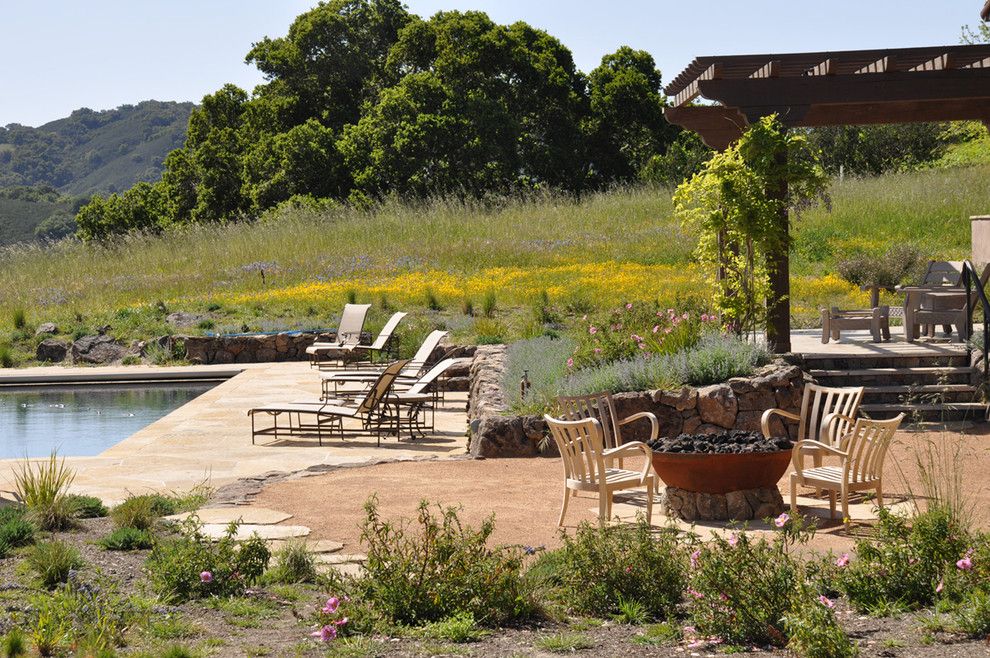 Decomposed Granite Patio for a Rustic Landscape with a Stone Wall and Firepit and Pool by Arterra Landscape Architects