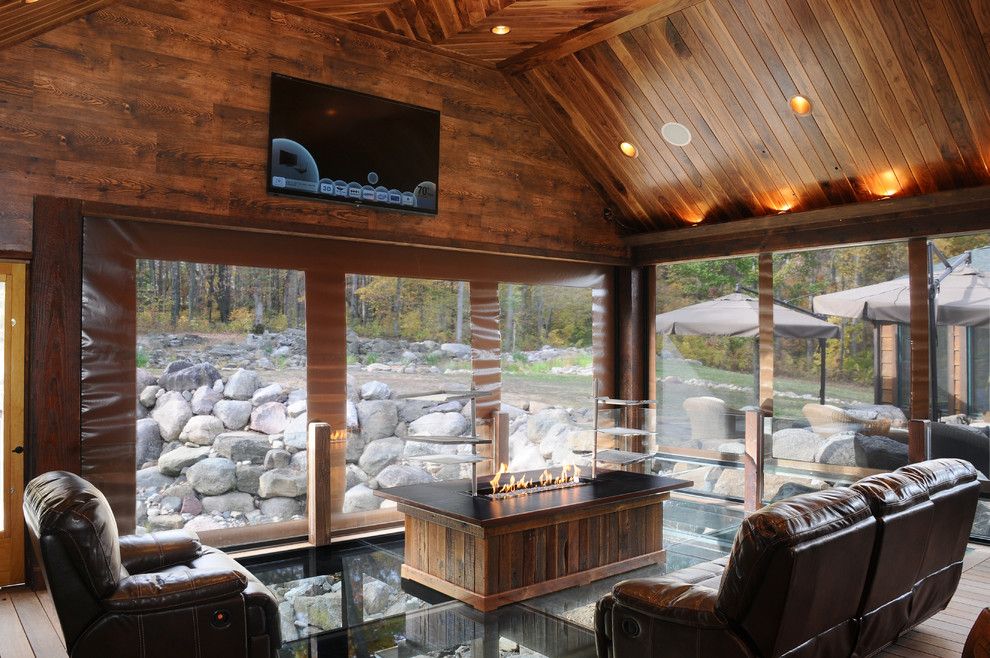 Environmental Stoneworks for a Rustic Porch with a Wood Floor and Outdoor Living Space by Jg Development, Inc.