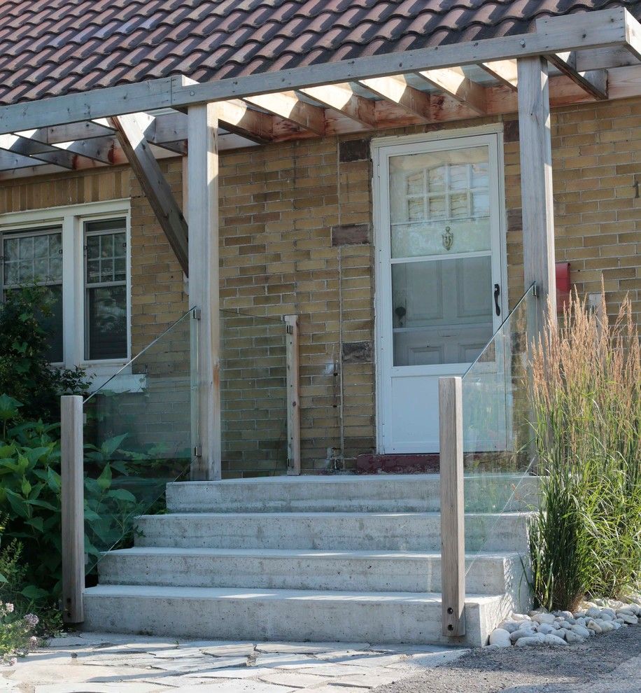 Front Stoop for a Contemporary Entry with a Front Stoop and Front Entry with Pergola and Glass Railing by Heritage Stoneworks Ltd.