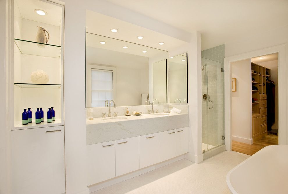 Handsome Cabinets for a Modern Bathroom with a Glass Shelves and Spa Bath in 1915 Colonial by Charlie Allen Renovations, Inc.