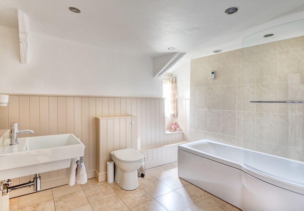 Hollyhock House for a Farmhouse Bathroom with a Beige Tile Wall and Winslade Manor by Colin Cadle Photography