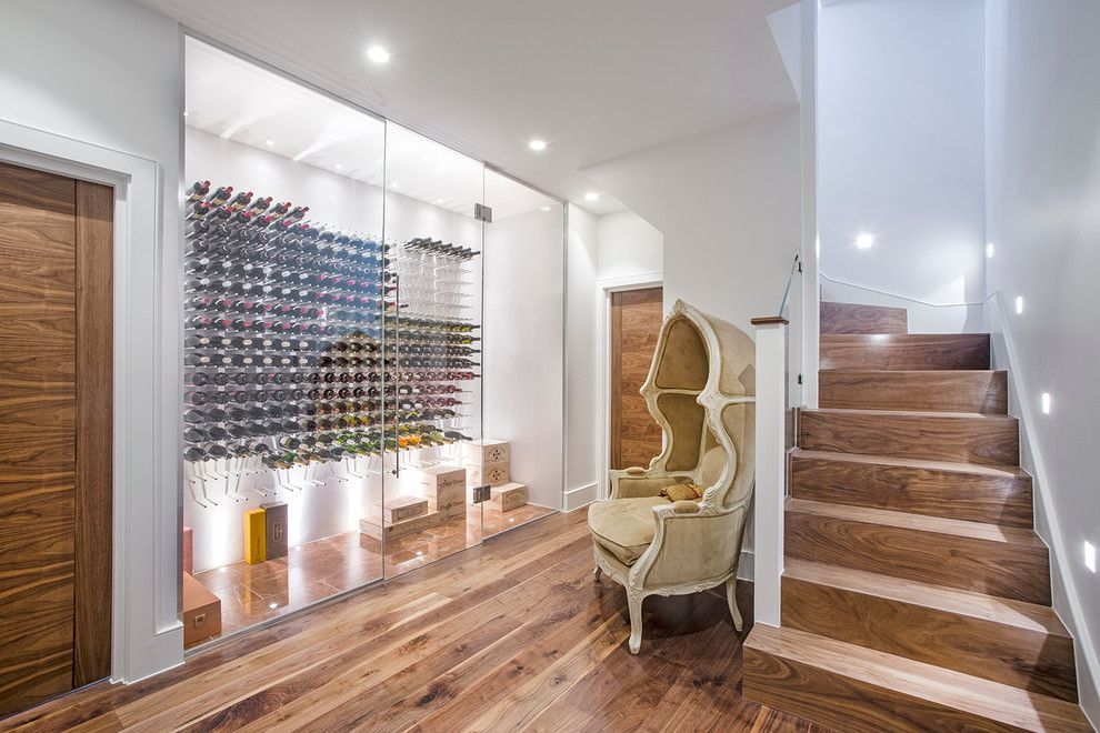 Midwest Basement Systems for a Contemporary Wine Cellar with a Wooden Staircase and a Stunning Wine Room, Which Also Makes a Striking Addition to the Basement Lobby by London Basement