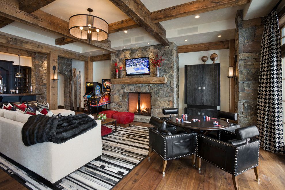 Rolly Chair for a Rustic Family Room with a Red Ottoman and West Slopeside Chalet by Locati Architects