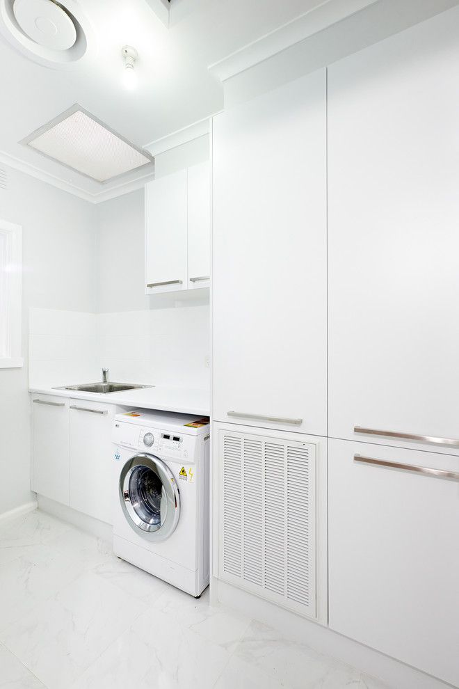 Tankless Water Heater vs Tank for a Modern Laundry Room with a White Crown Molding and Andrew Lee Kitchen and Bathroom Renovation Project by Damco Kitchens