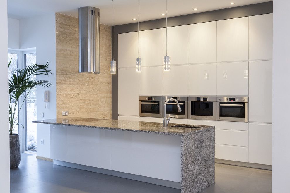 Waterfall Countertop for a Contemporary Kitchen with a Stainless Hood and Kitchens by Modern Style Construction Llc