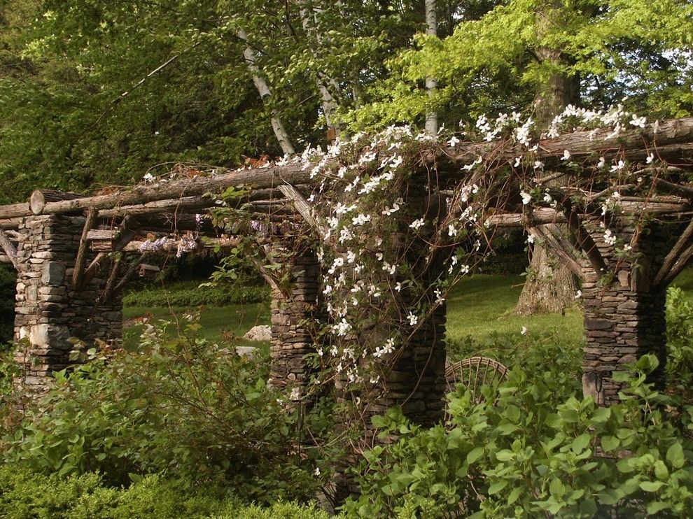 Arbors on Post Oak for a Rustic Landscape with a Stone Pillars and Cascading Jasmine on the Pergola by Conte & Conte, Llc