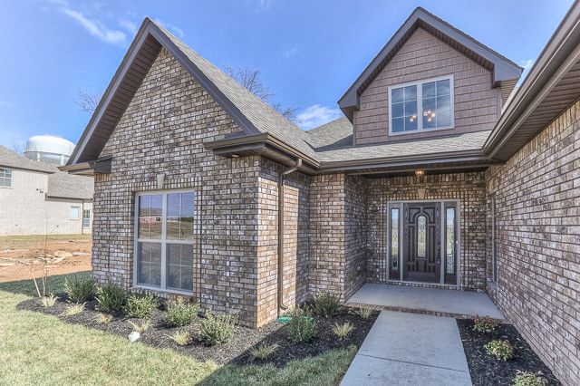 Buster Crabbe Pools for a Traditional Exterior with a Village Terrace and All Brick Ranch Home in Gated Community by Crabbe Homes