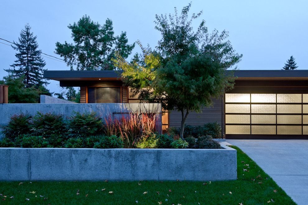 Cinder Block Retaining Wall for a Midcentury Exterior with a Overhang and Enatai Midcentury Modern by Reruchastudio