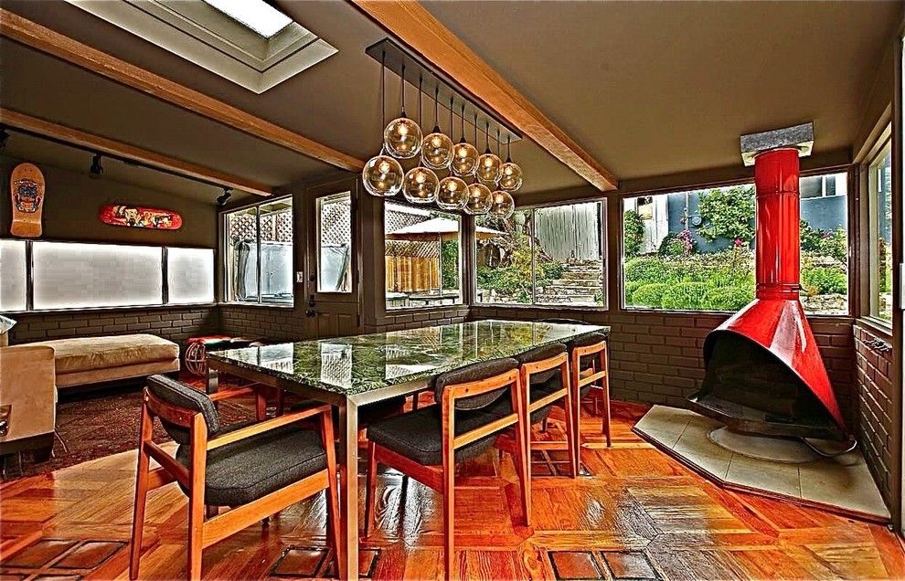 Pacific Energy Wood Stove for a Midcentury Dining Room with a Skylights and Pacific Palisades by Howard Fischer Design