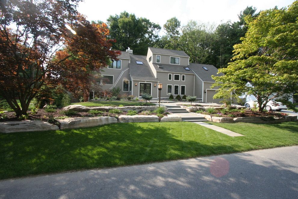 Railroad Tie Retaining Wall for a Contemporary Landscape with a Contemporary Design and Boulder Walls, Bluestone Patios and Plantings by Perennial Landscaping