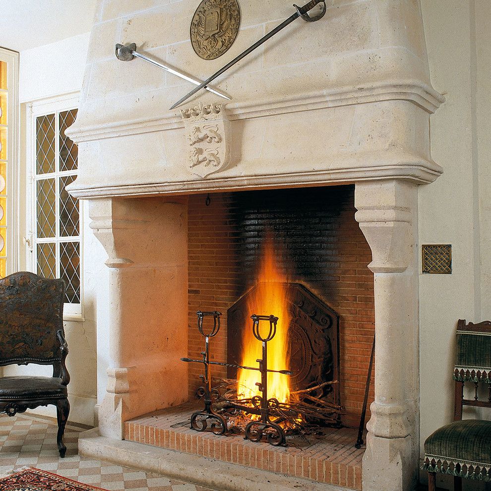 Tailor Lofts for a Mediterranean Living Room with a Stone Mantle and Hand Carved Fireplaces by Ancient Surfaces