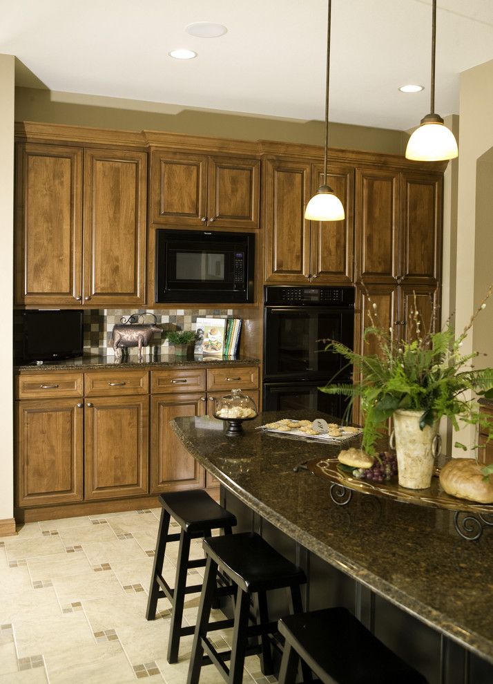 The Seasons of Cherry Creek for a Traditional Kitchen with a Dark Stone Countertop and Custom Arch Cabinets by Cherry Creek, Inc.