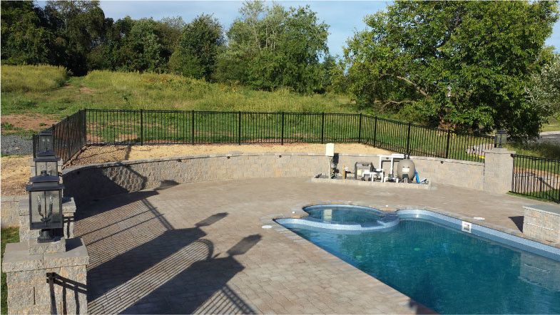 Viking Fence for a Contemporary Pool with a Segmental Retaining Wall 350sf and Pool Deck Hardscaping by Green Construction Group, Inc.